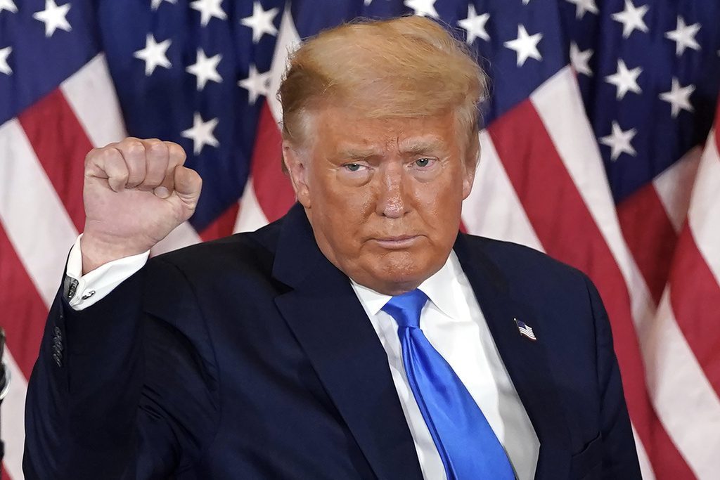 FILE - President Donald Trump pumps his fist after speaking in the East Room of the White House, early Wednesday, Nov. 4, 2020, in Washington. Trump is already laying a sweeping set of policy goals should he win a second term as president. Priorities on the Republican's agenda include a mass deportation operation, a new Muslim ban and tariffs on all imported goods. (AP Photo/Evan Vucci, File)