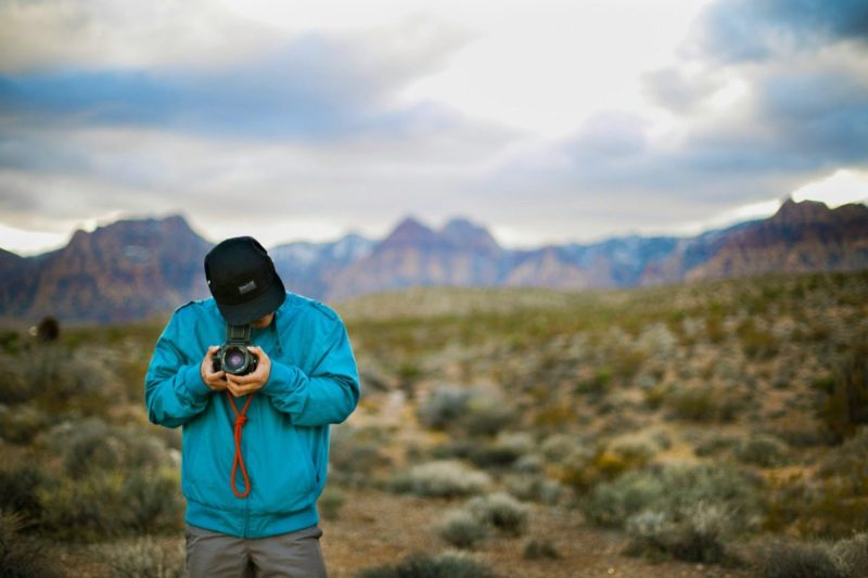 Man in blue jacket taking a photo.