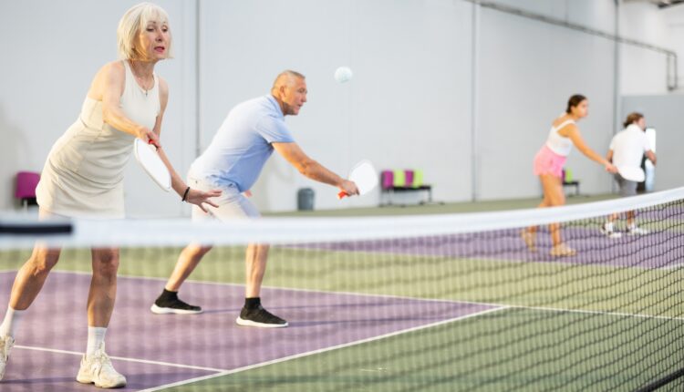 Senior couple playing doubles pickleball.
