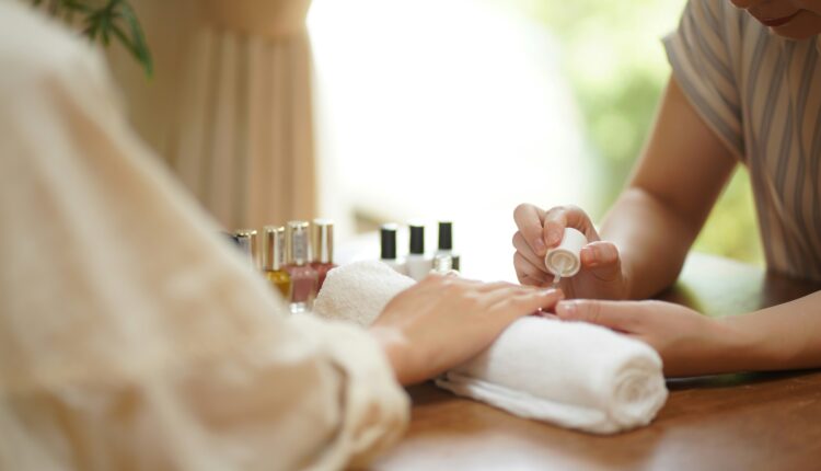 A manicurist painting a client's nails
