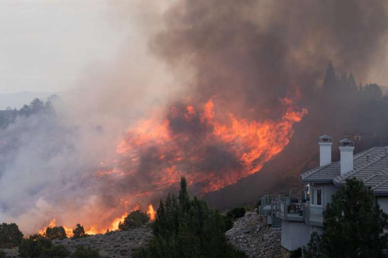 Flames engulf the vegetation surrounding residential neighborhoods as the Pinehaven Fire burns on November 17, 2020 in Reno, Nevada. (Photo by Trevor Bexon/Getty Images)