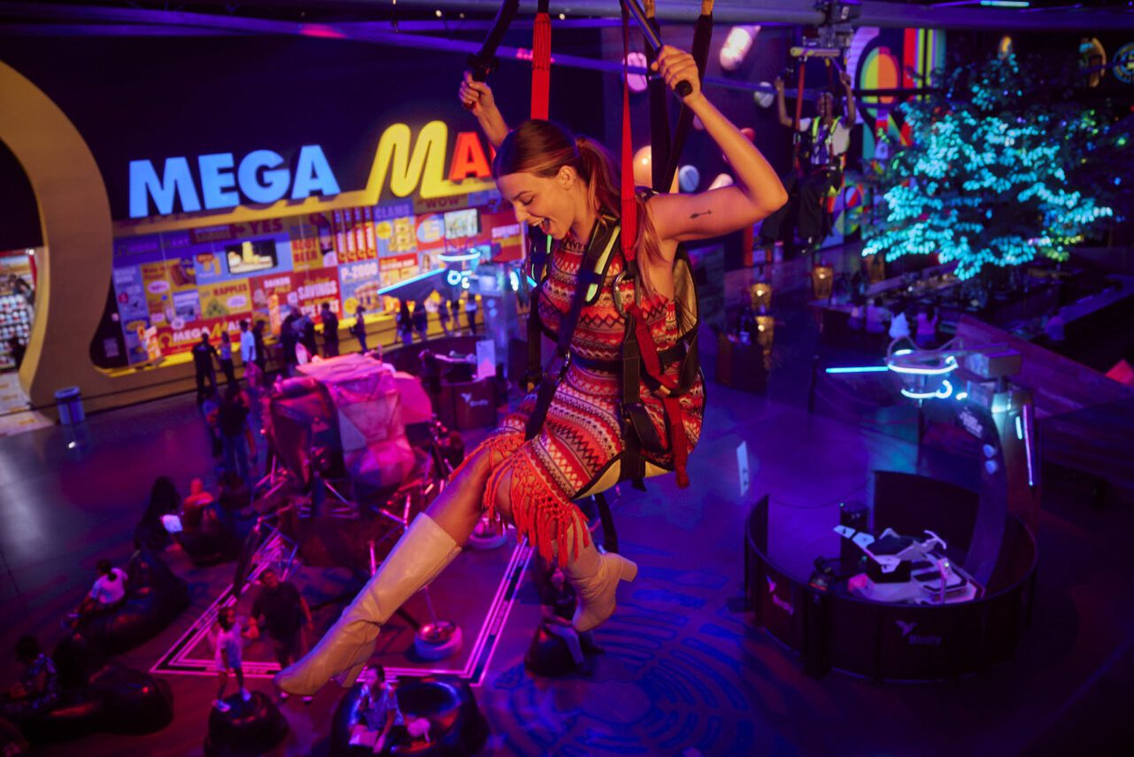 A woman ziplining in an indoor adventure park. 