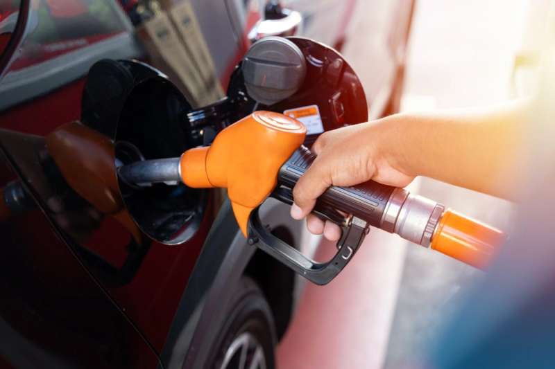 hand filling up gas tank at station.