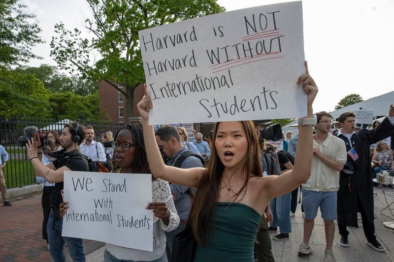 People hold up signs during the Harvard Students for Freedom rally in support of international students at the Harvard University campus in Boston, Massachusetts, on May 27, 2025.