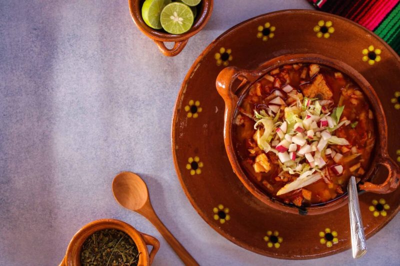 A rich, savory broth, made with tender chicken or pork and hominy, pozole is often garnished with veggies like shredded lettuce or cabbage, chili peppers, onion, garlic, and radishes, as well as avocado and lime.