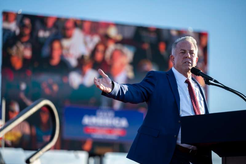 Gov. Joe Lombardo speaking on stage at a Trump rally.