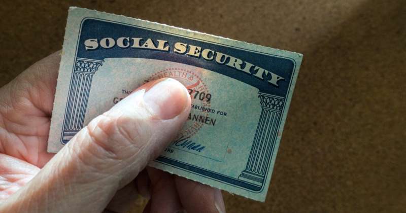 Fingers clutching a Social Security card