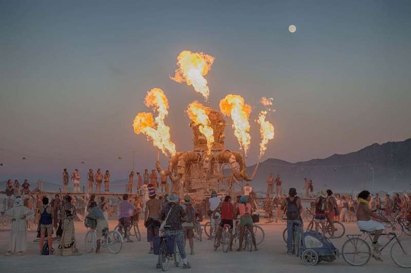 Burners ride bikes around the Black Rock Desert playa to interact with large-scale art during Burning Man