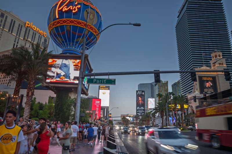 Tourists walk down the Las Vegas Strip as the sun sets.